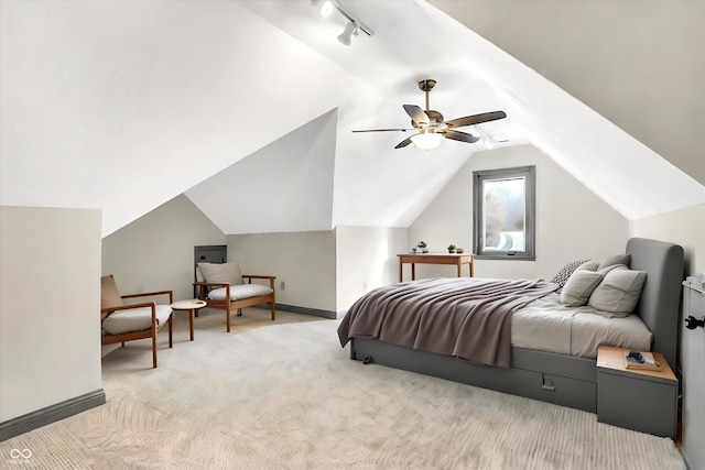 bedroom featuring ceiling fan, rail lighting, light carpet, and vaulted ceiling