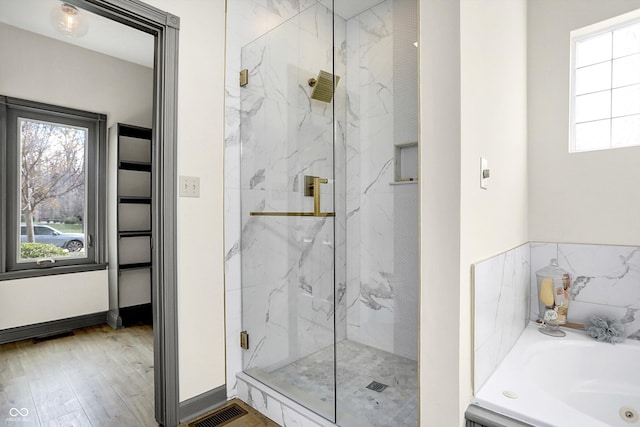 bathroom with shower with separate bathtub and hardwood / wood-style flooring