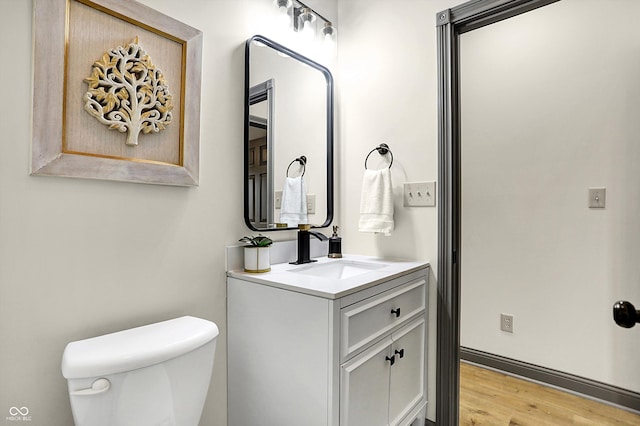 bathroom with vanity, wood-type flooring, and toilet