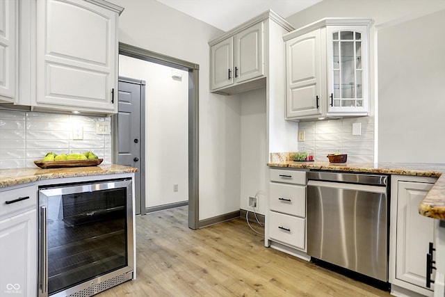 kitchen featuring tasteful backsplash, dishwasher, white cabinets, and beverage cooler