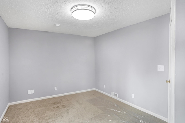 spare room with carpet floors and a textured ceiling