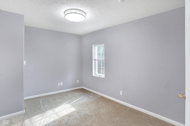 carpeted empty room featuring a textured ceiling