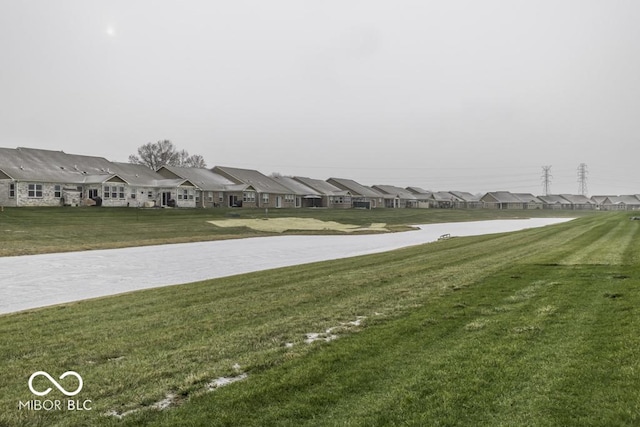 surrounding community featuring a lawn and a water view