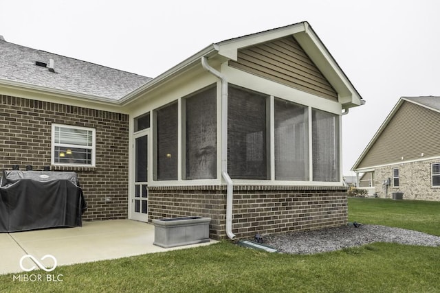 back of house featuring a sunroom, a yard, and a patio