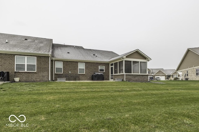 back of property featuring a sunroom and a yard