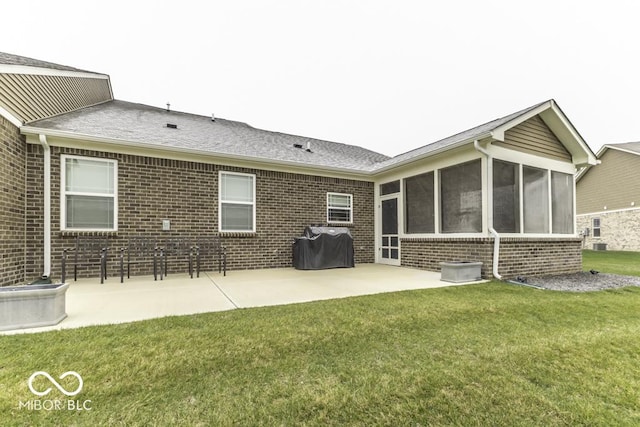 rear view of property with a sunroom, a patio area, and a lawn