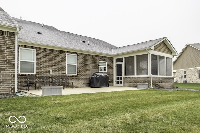 back of house with a lawn, a sunroom, and a patio