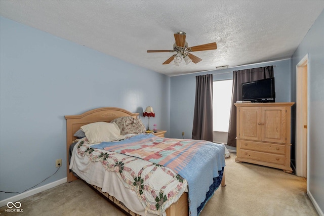 bedroom featuring ceiling fan, light colored carpet, and a textured ceiling