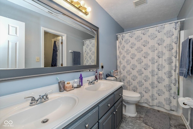 bathroom with vanity, toilet, and a textured ceiling