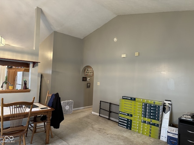 dining room with light colored carpet, high vaulted ceiling, and sink