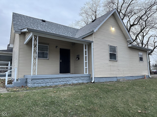 view of front of home with covered porch and a front lawn