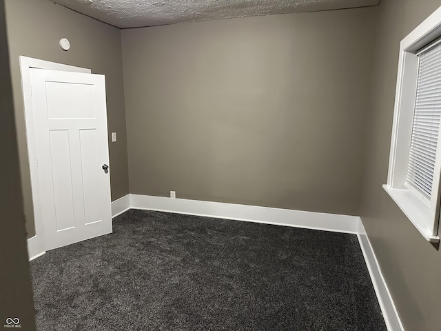 carpeted spare room featuring a textured ceiling