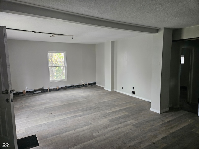 empty room with hardwood / wood-style floors and a textured ceiling