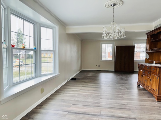 unfurnished dining area with crown molding, light hardwood / wood-style flooring, and a notable chandelier