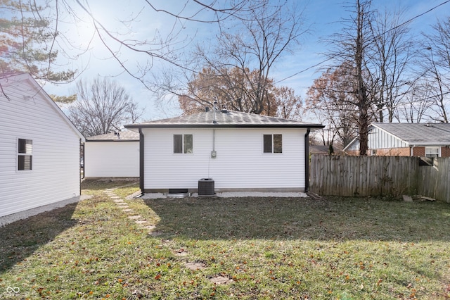 back of property with a lawn and cooling unit