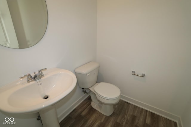 bathroom featuring sink, wood-type flooring, and toilet