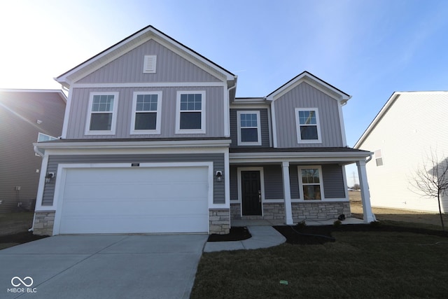 view of front of property featuring covered porch, a front yard, and a garage