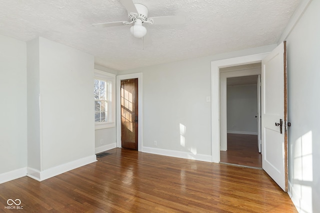 unfurnished room featuring ceiling fan, wood-type flooring, and a textured ceiling