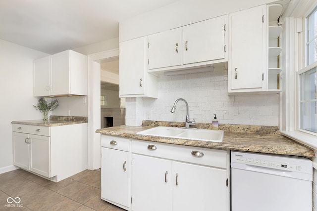 kitchen with white cabinetry, dishwasher, sink, tasteful backsplash, and light tile patterned floors