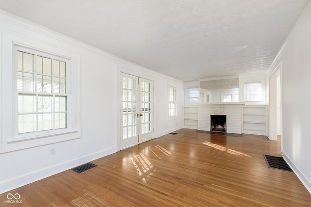 unfurnished living room with a fireplace, hardwood / wood-style floors, and a healthy amount of sunlight