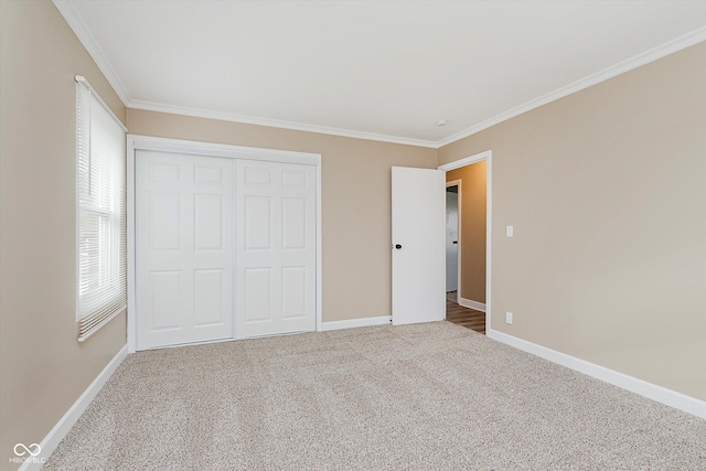 unfurnished bedroom featuring carpet, a closet, and crown molding