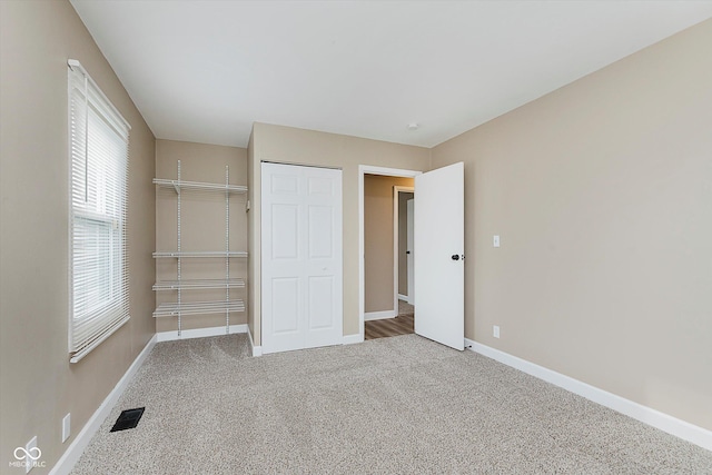 unfurnished bedroom with a closet and carpet floors