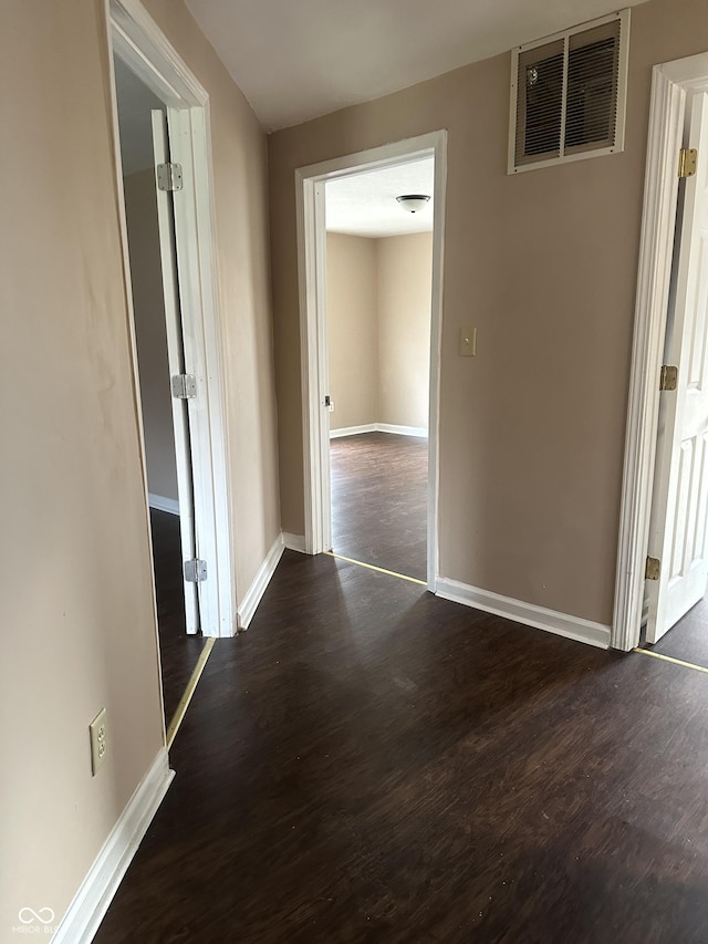 corridor with dark hardwood / wood-style flooring