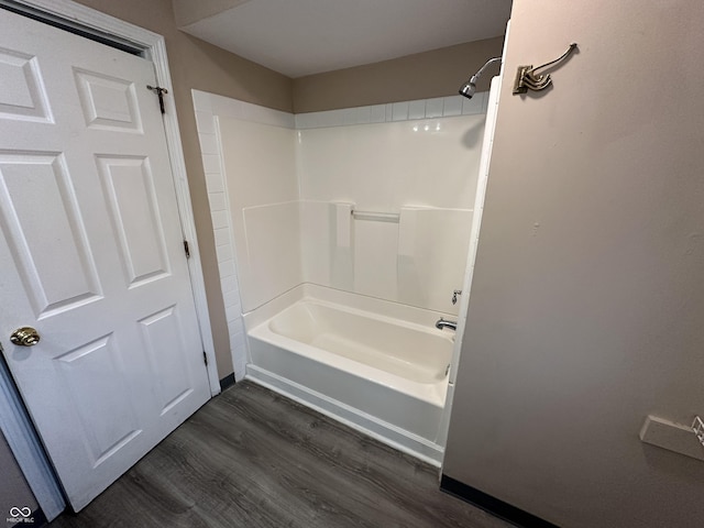 bathroom with hardwood / wood-style floors and shower / washtub combination