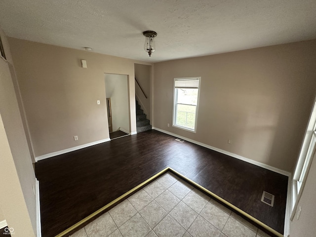 spare room featuring wood-type flooring and a textured ceiling