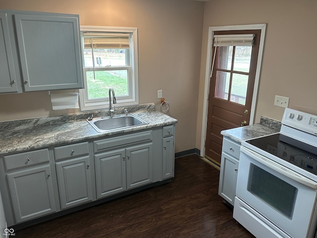 kitchen featuring white range with electric cooktop, plenty of natural light, white cabinetry, and sink