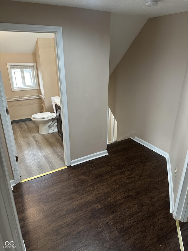 bonus room with a textured ceiling, dark hardwood / wood-style flooring, and lofted ceiling