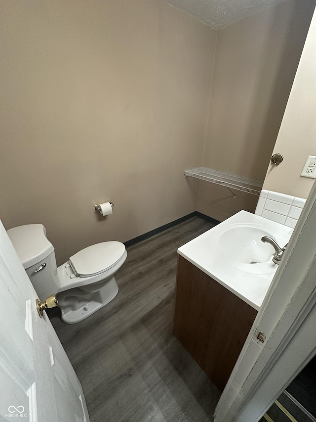 bathroom featuring vanity, toilet, and wood-type flooring