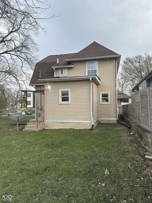 rear view of house featuring a lawn