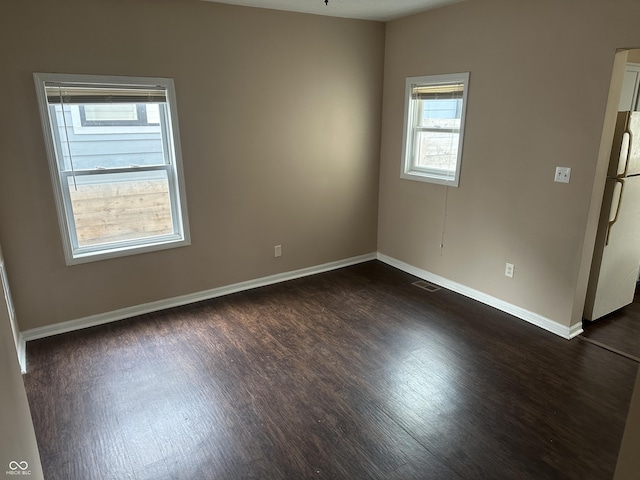 spare room with dark wood-type flooring