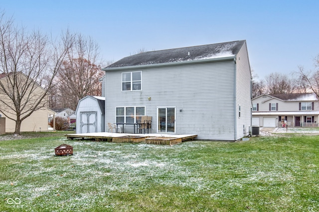 back of house featuring a yard, a fire pit, a deck, central AC, and a storage shed