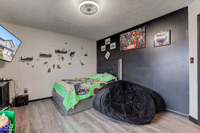 bedroom featuring a textured ceiling and light hardwood / wood-style flooring