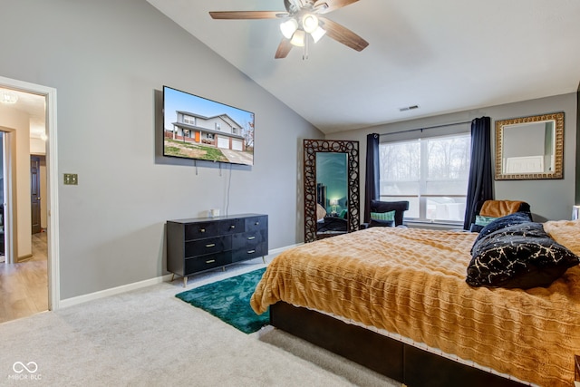 carpeted bedroom with ceiling fan and vaulted ceiling