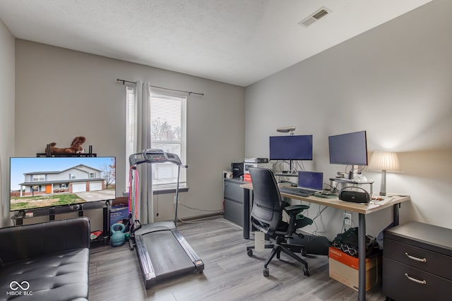 office area featuring light hardwood / wood-style floors and a textured ceiling