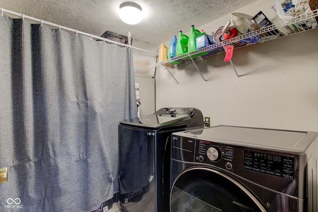 laundry room featuring a textured ceiling and washer and clothes dryer