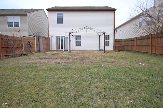 rear view of property featuring a gazebo and a yard