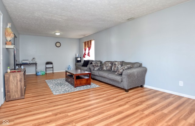 living room with light hardwood / wood-style floors and a textured ceiling