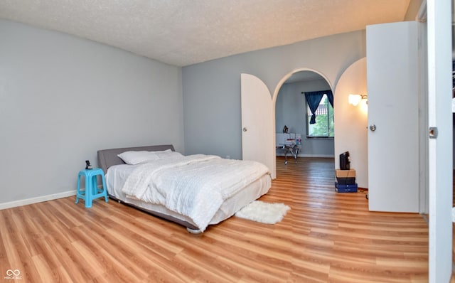 bedroom with light hardwood / wood-style flooring and a textured ceiling