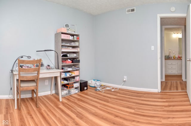 interior space with light hardwood / wood-style floors and a textured ceiling