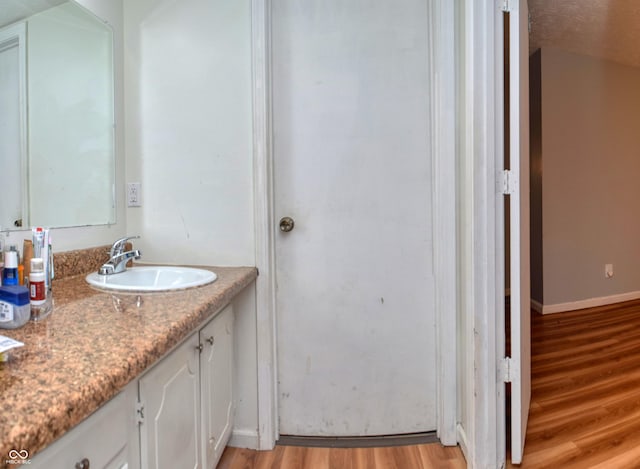 bathroom featuring vanity, a textured ceiling, and hardwood / wood-style flooring