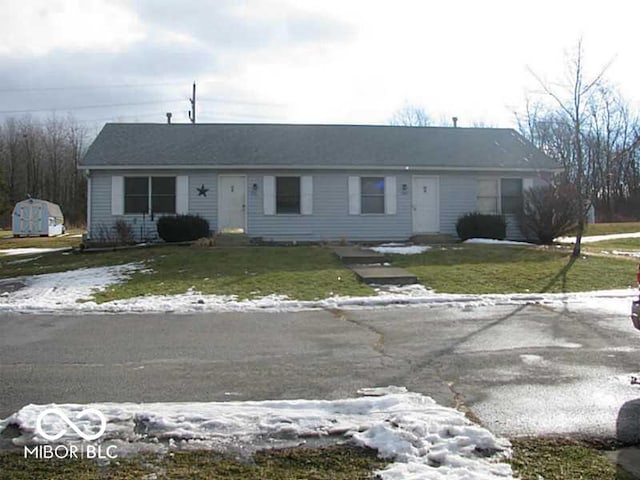 single story home featuring a shed and a front yard