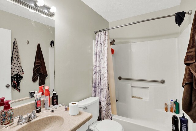 full bathroom featuring shower / bath combination with curtain, a textured ceiling, toilet, and sink