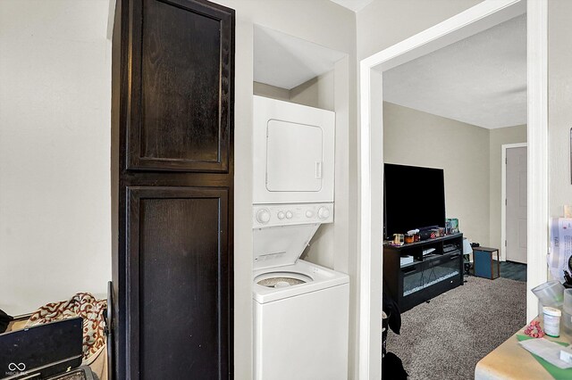 clothes washing area featuring carpet floors and stacked washer and clothes dryer