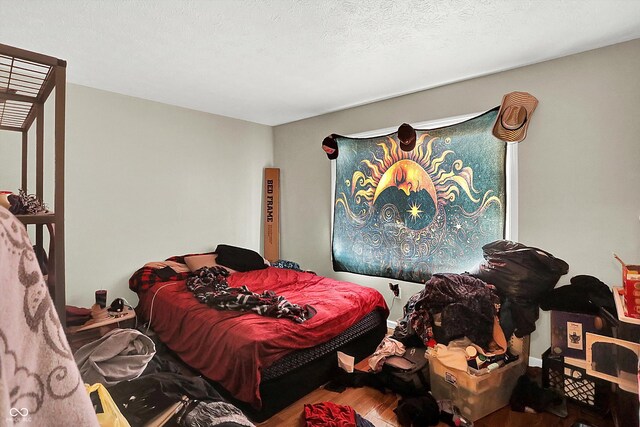 bedroom featuring hardwood / wood-style floors and a textured ceiling