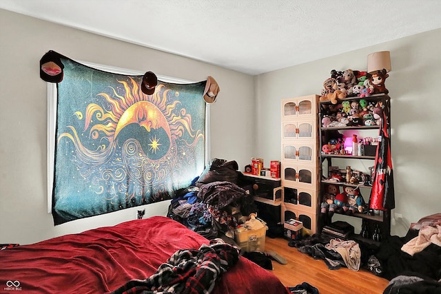 bedroom featuring wood-type flooring and a textured ceiling