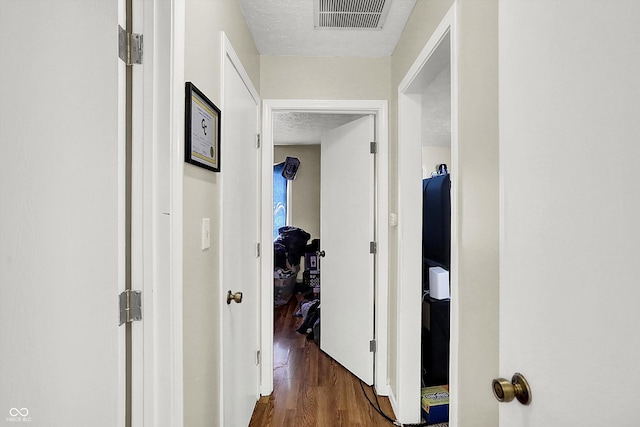 corridor featuring dark hardwood / wood-style floors and a textured ceiling